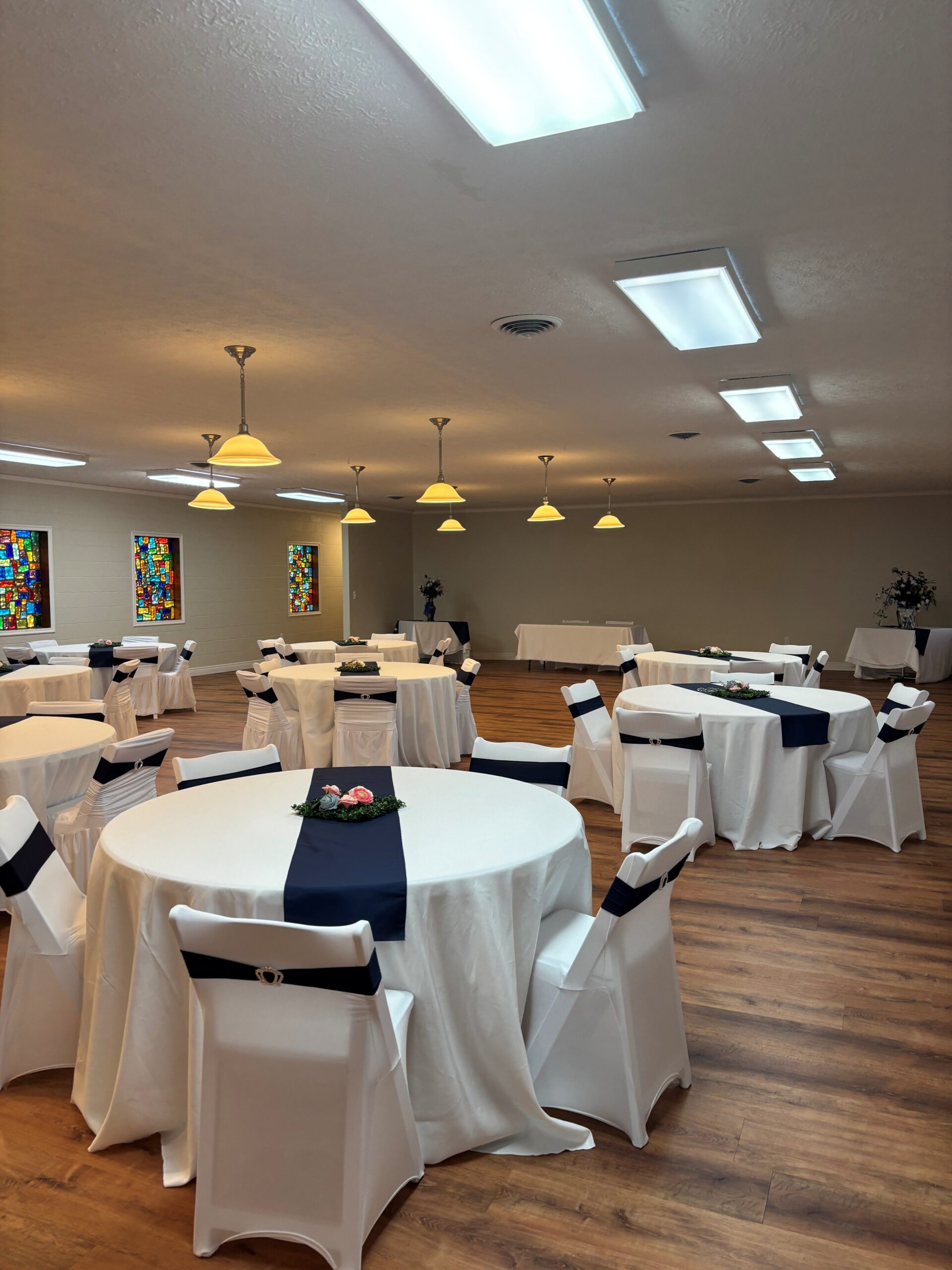 Dayton event venue reception hall with round tables, white linens, and navy chair sashes at Chapel on the Lane